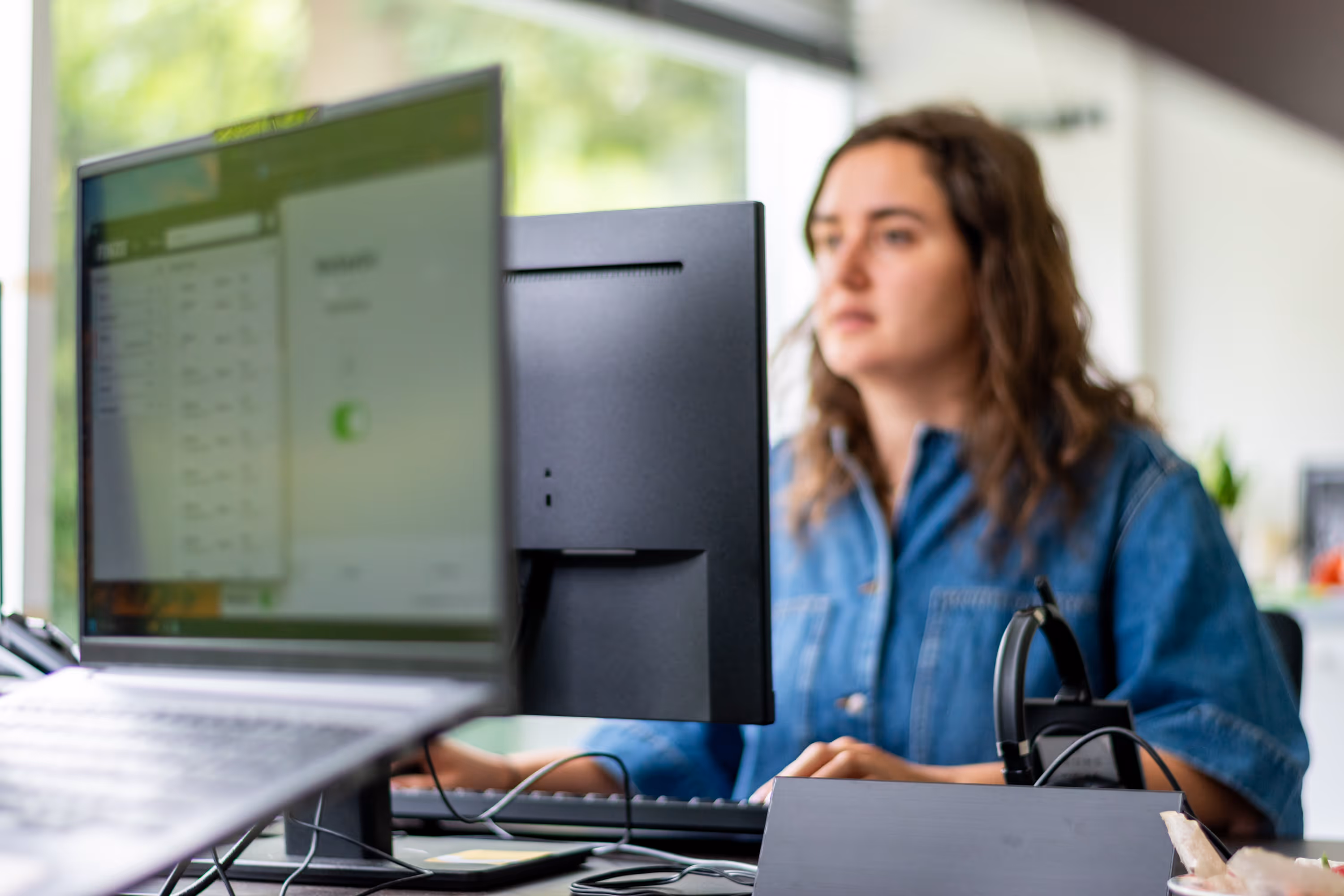 Een vrouwelijke begeleider aan het werk aan een computer. 
