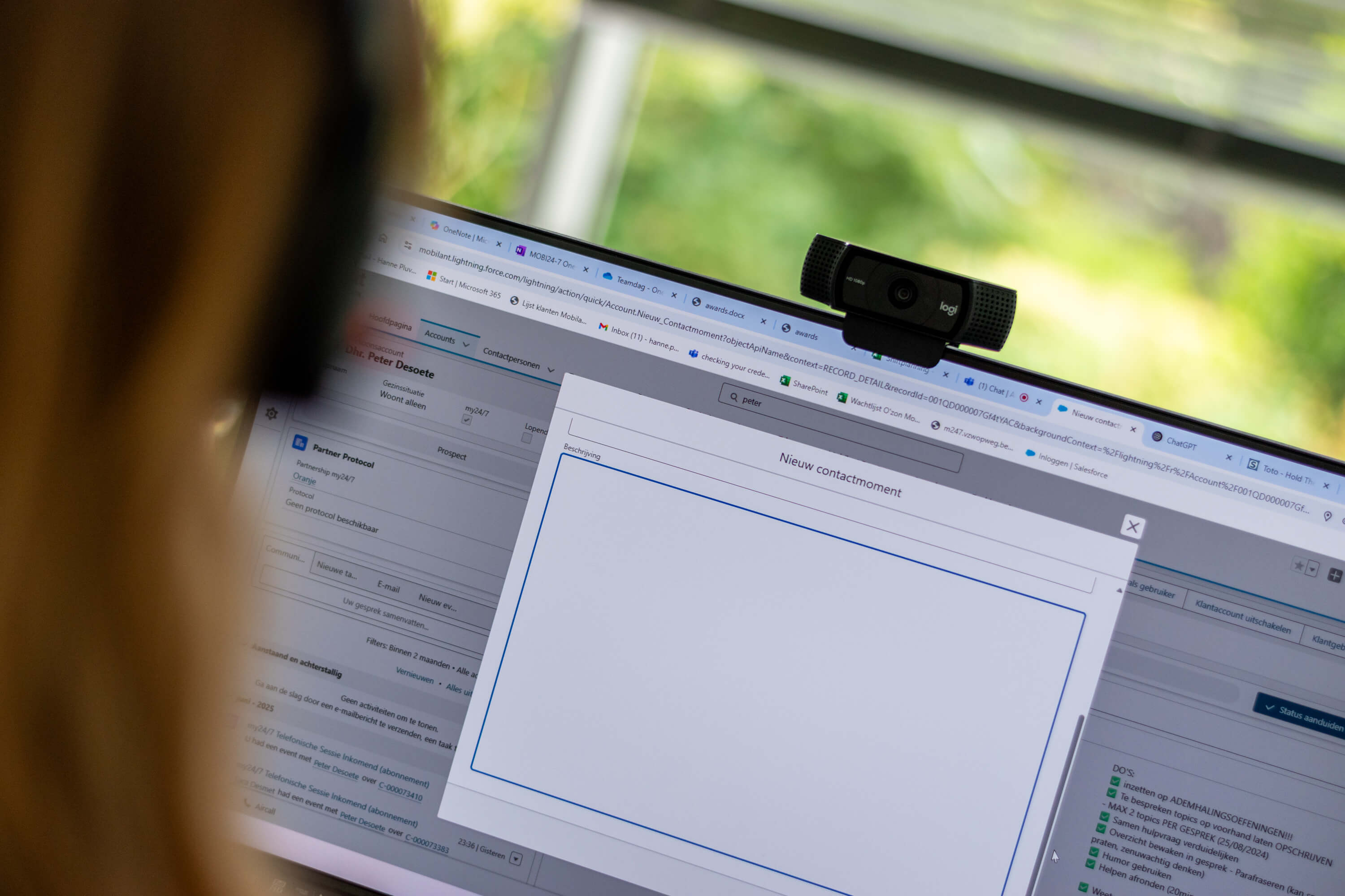 Een camera voor videobellen en een computerscherm met 'nieuw contactmoment' op.