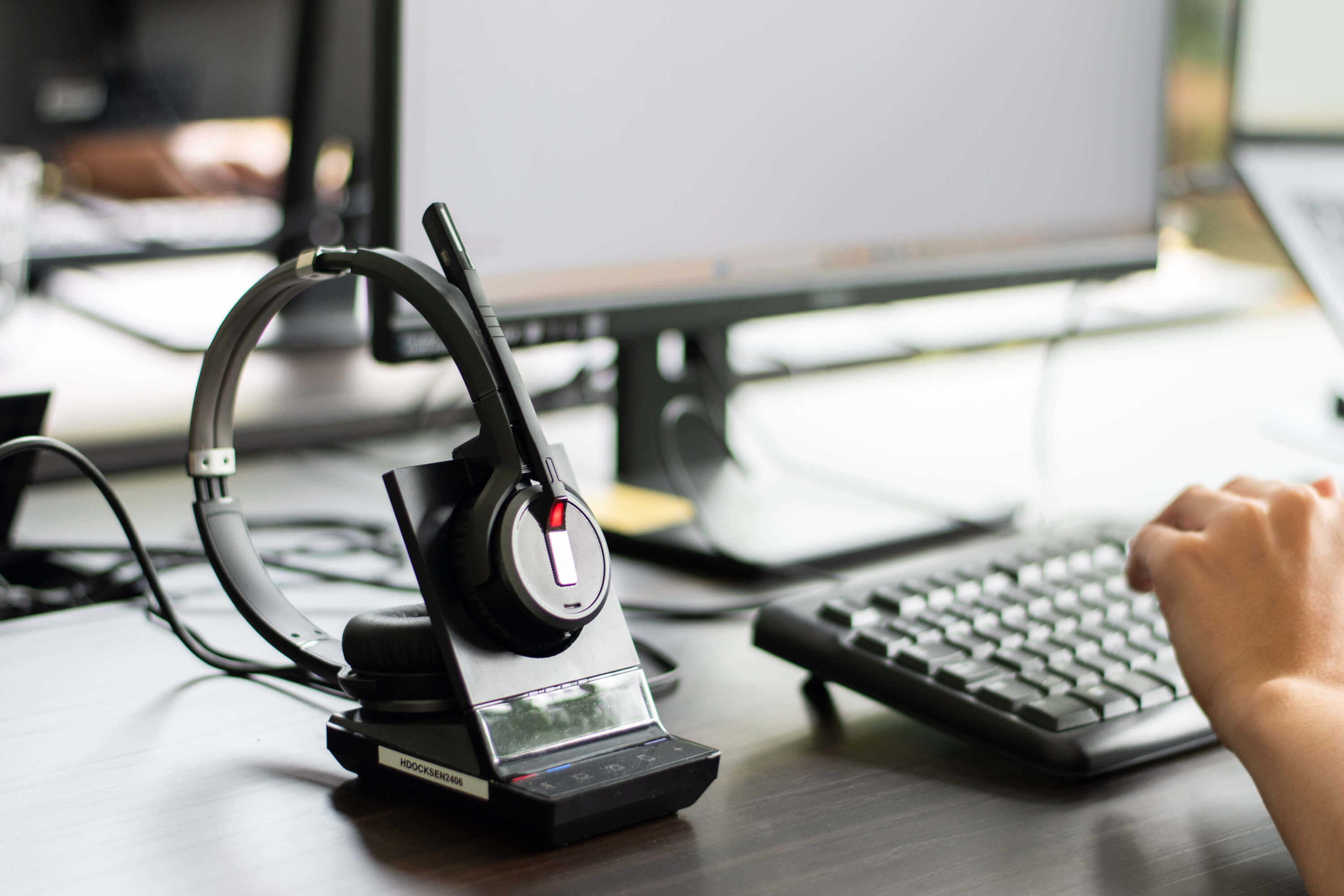 Een koptelefoon en een toetsenbord met een hand.