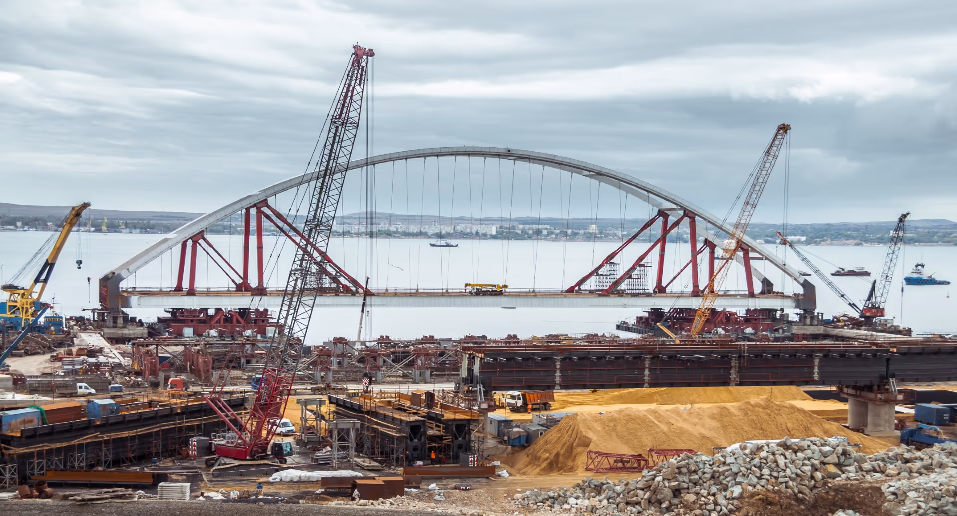 A large crane is overlooking a construction site.