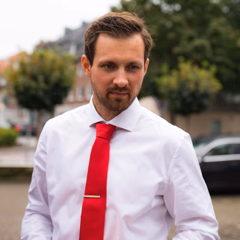 A man wearing a white shirt and a red tie.