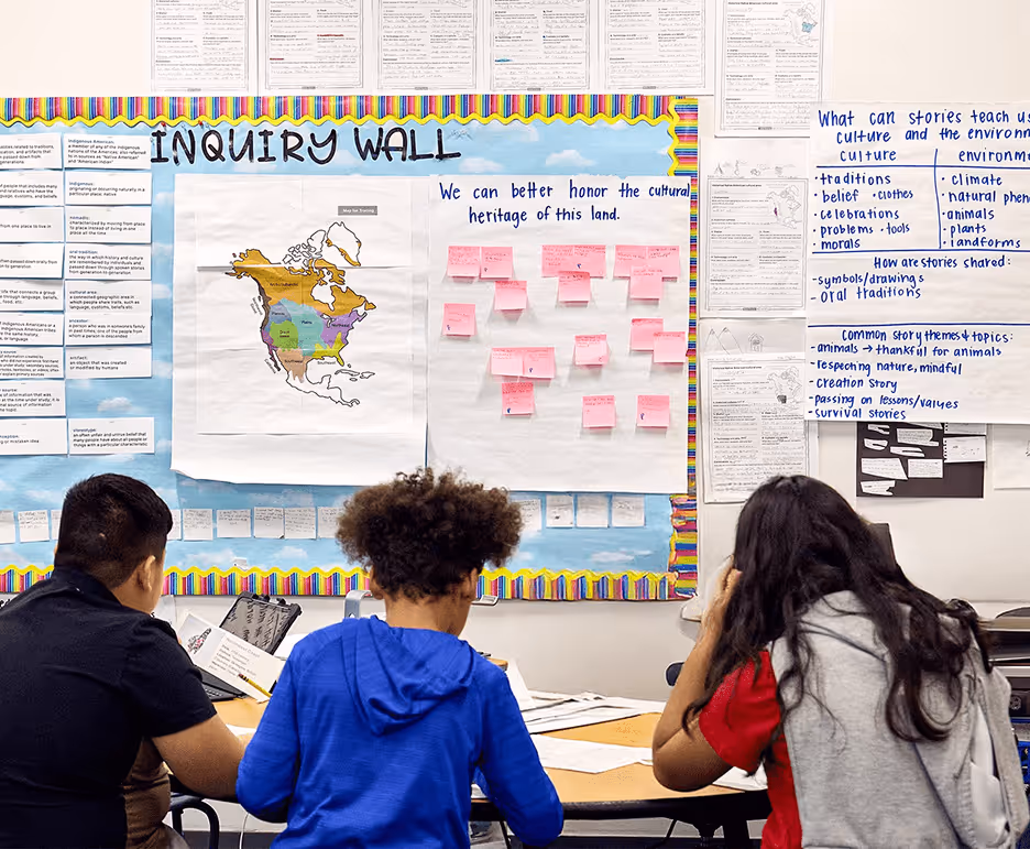 students working with a bulletin board in the background