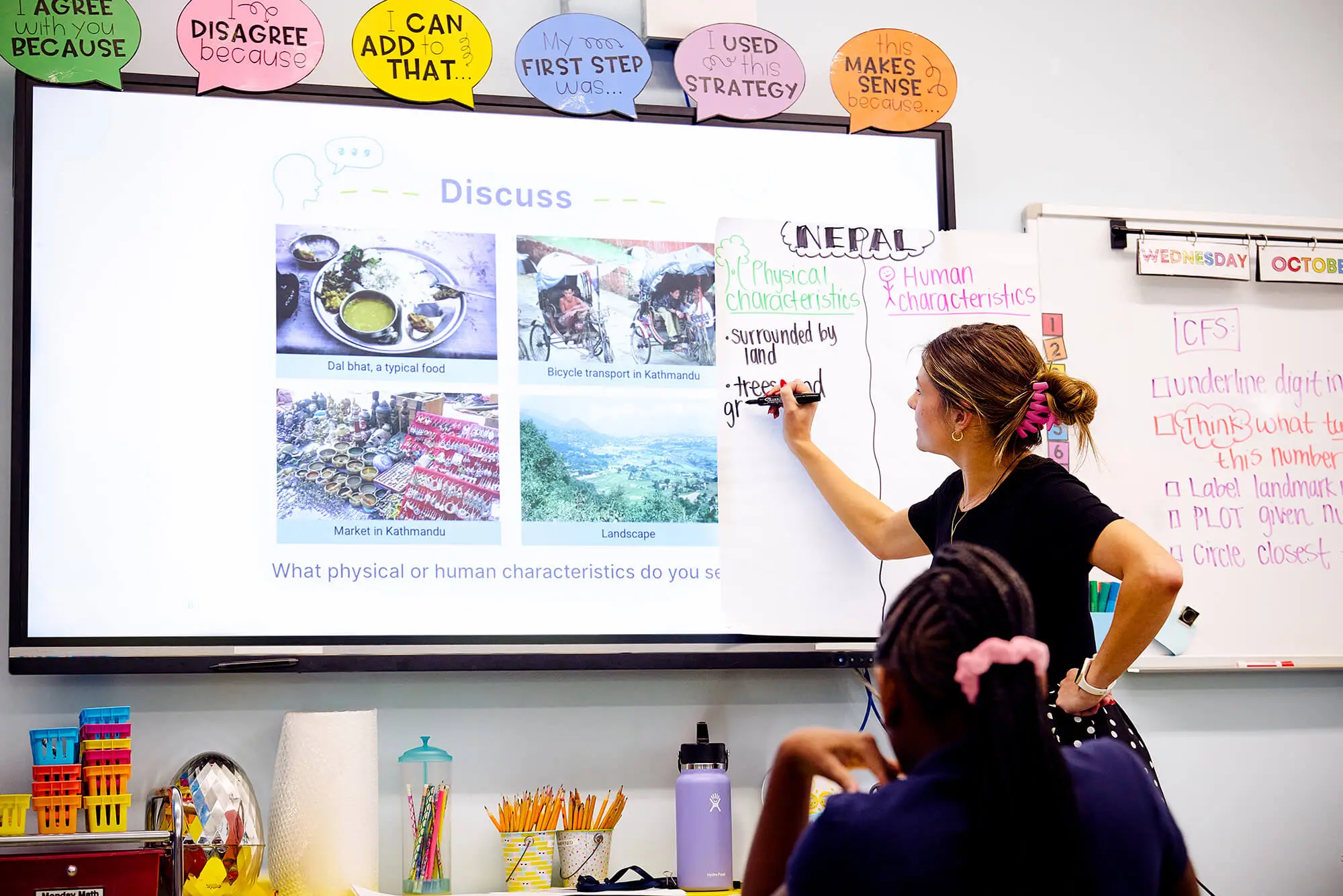 A teacher on the whiteboard showing Inquiry Journey's Teaching Slide Decks