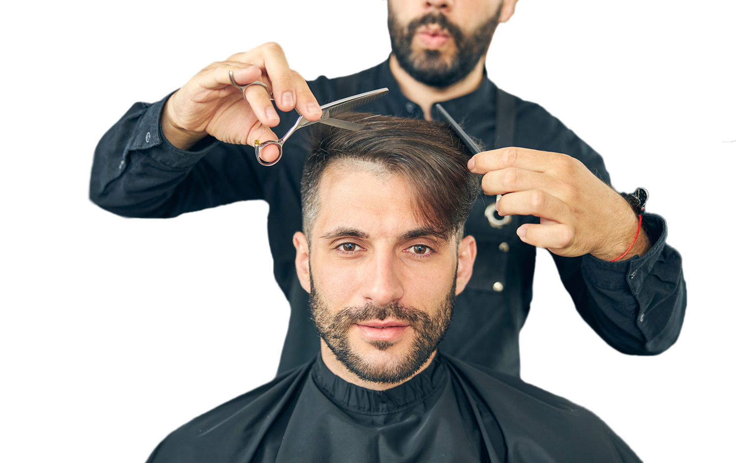 Barber cutting a man's hair using scissors and a comb while the man looks at the camera.