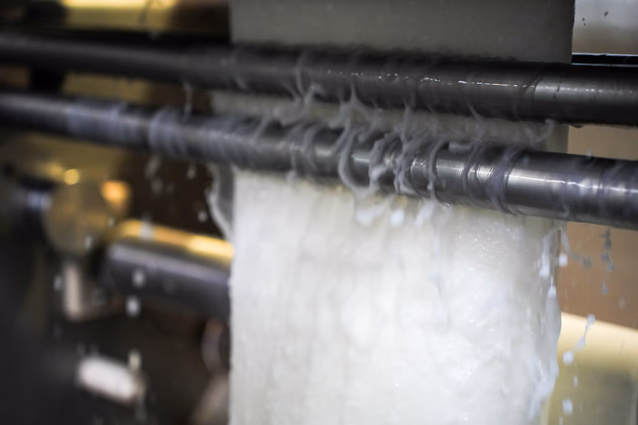 Row of white industrial control panels and equipment in a clean, bright manufacturing or laboratory environment.