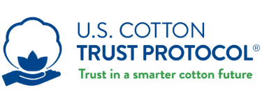 Close-up of industrial textile machinery with multiple spools of white thread in a factory setting.