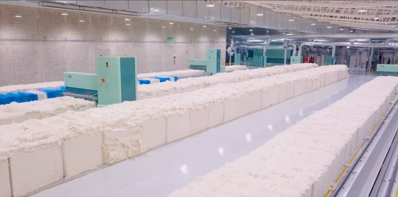 Close-up of water droplets sitting on soft blue and white textured surface with blurred blue background.