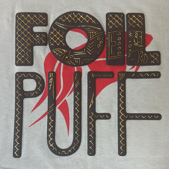 Man handling large rolls of white fabric in a spacious textile factory with industrial machines and bright overhead lighting.