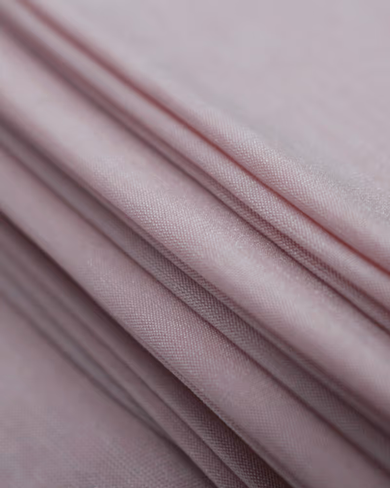 Close-up of a large spool of white thread on an industrial textile machine.