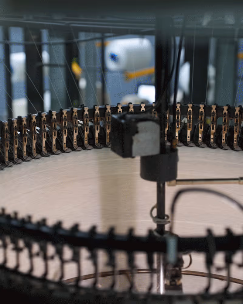 Large white textile yarn spools with one spool featuring a red center core.