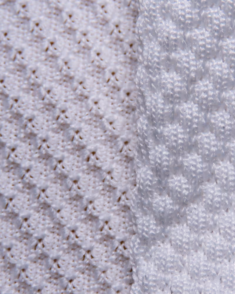 Close-up of water droplets on small blue and white textured beads.