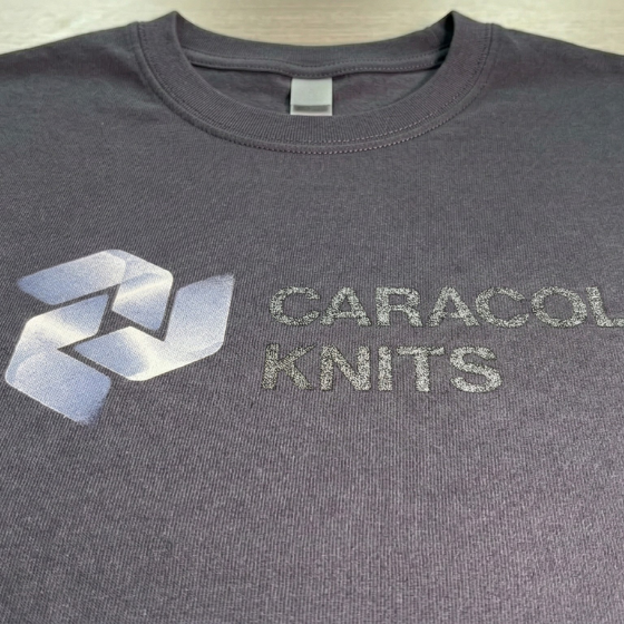 Man operating a large industrial fabric cutting machine with blue fabric in a spacious warehouse.