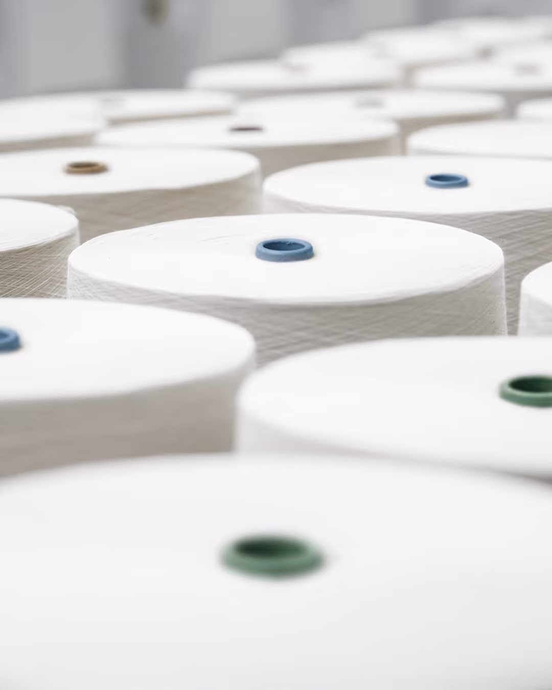 Close-up of water droplets on soft blue and white textured surface with a blurred blue background.