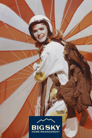 Big Sky logo overlaid on a vintage photograph of a woman holding a red and white parachute