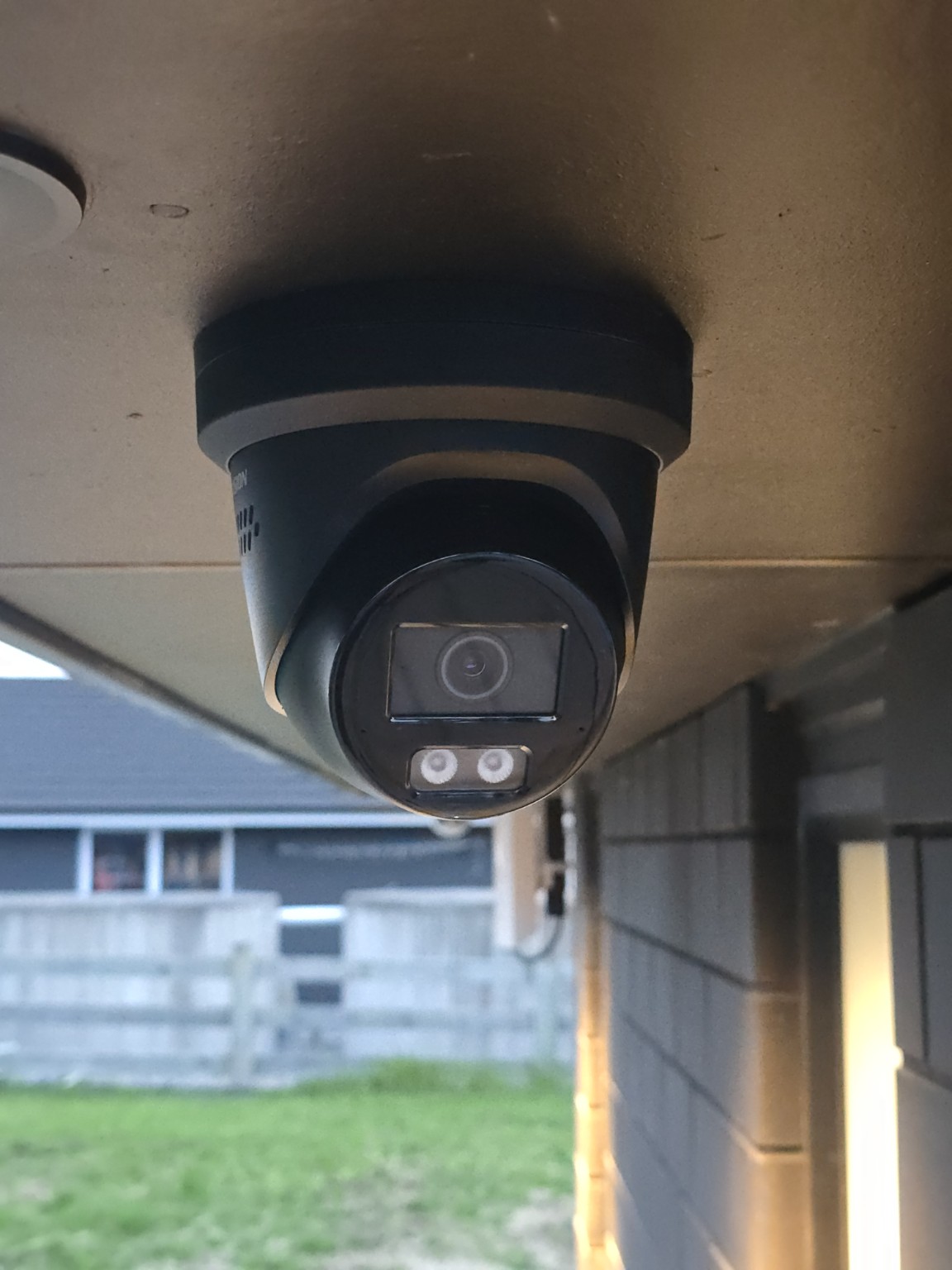 Outdoor security camera installed under the eaves of a home