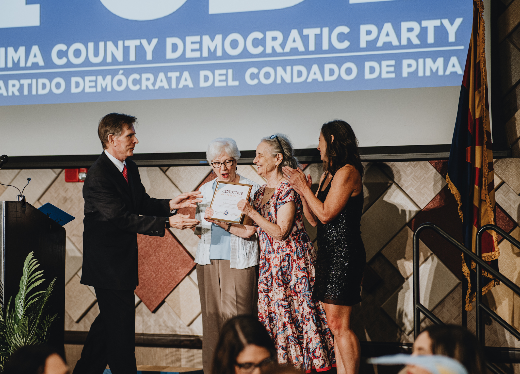 A woman is presented with an award for her service
