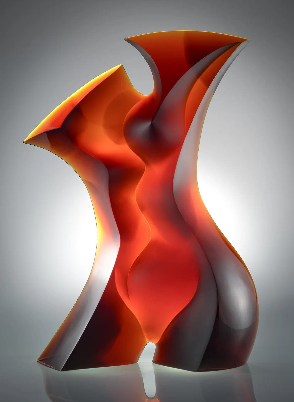 Red curved sculpture with dramatic lighting
