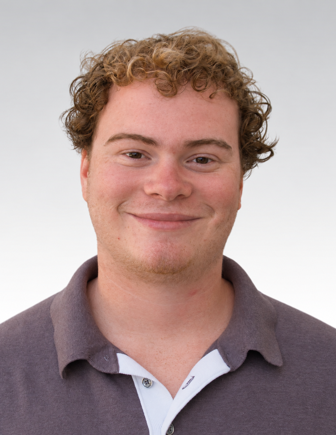  Josh man with a dark beard wearing a black collared shirt against a plain background.