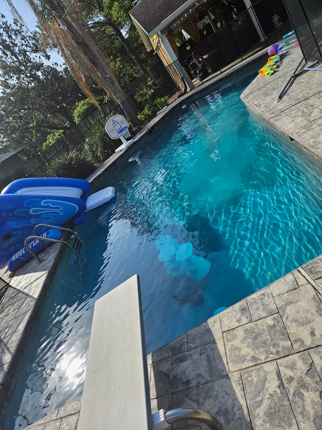 a pool with water toys and a pool in the background