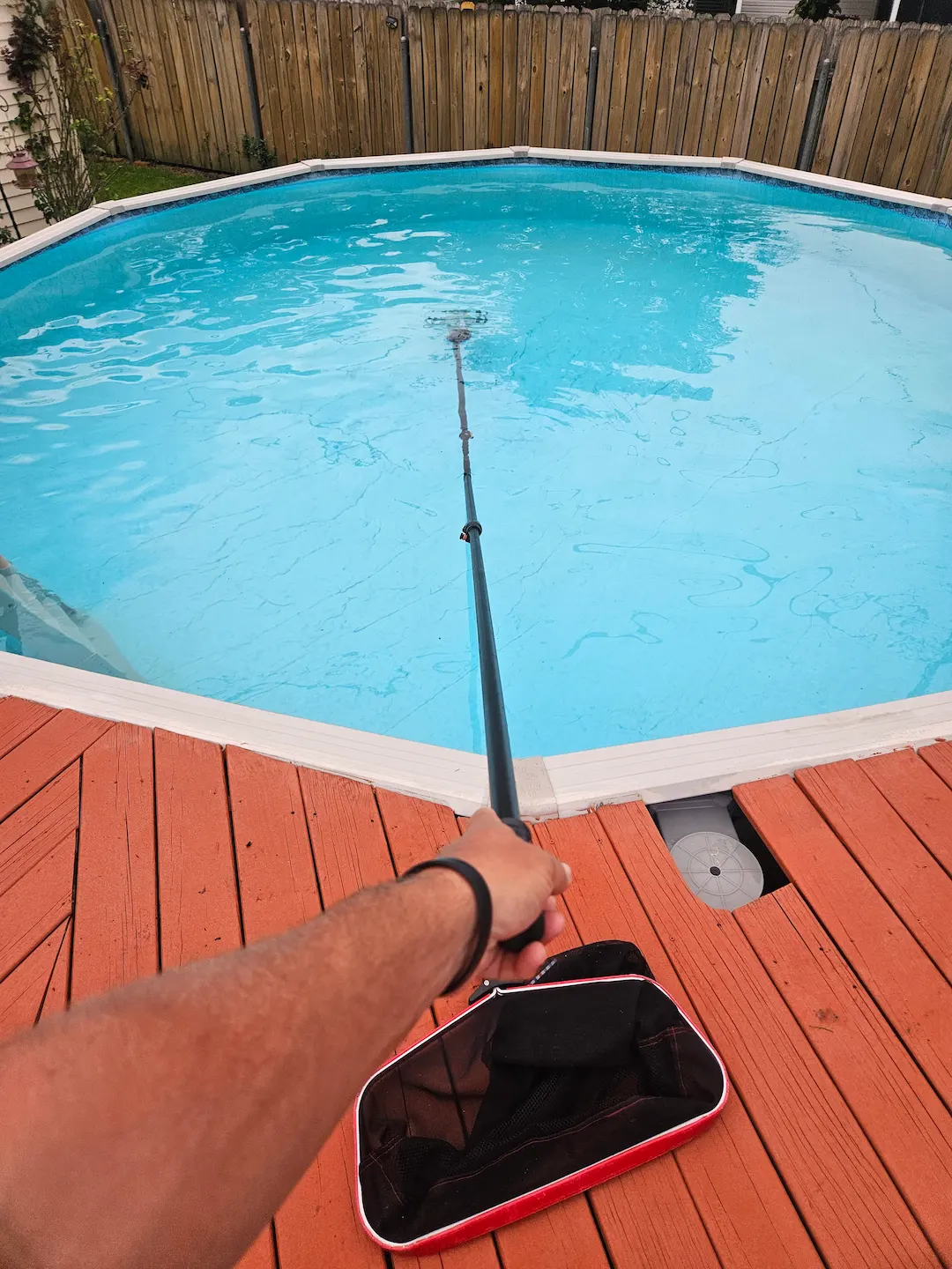 a person holding a fishing pole in front of a pool