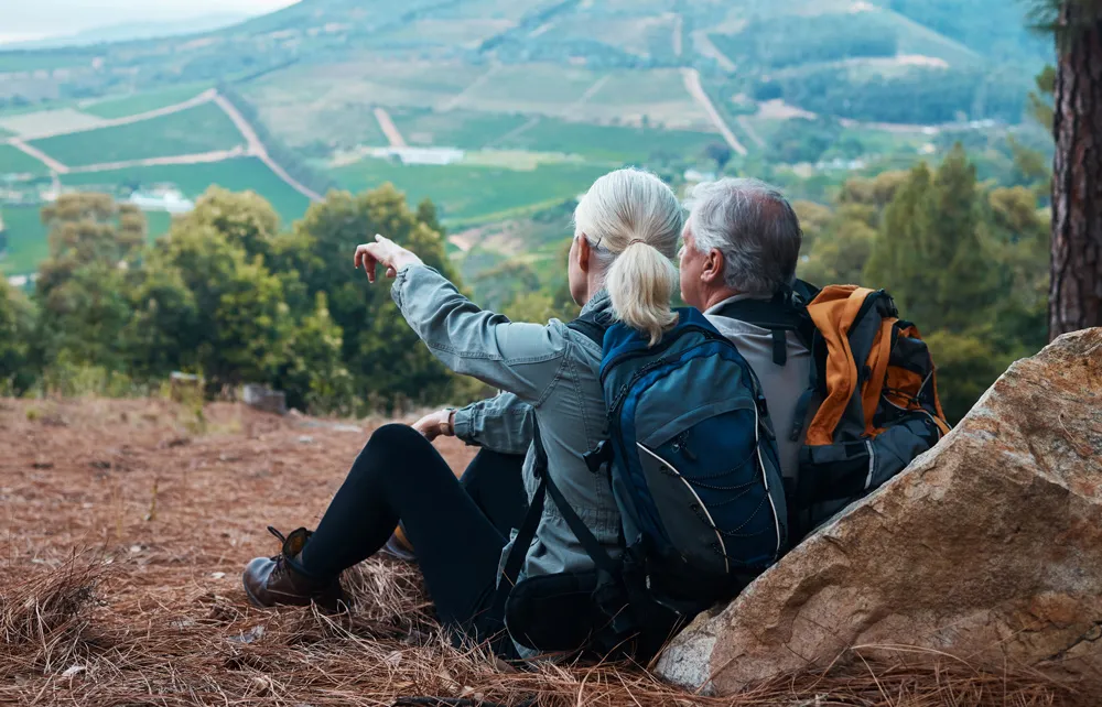 Pareja de jubilados en la montaña mirando el horizonte