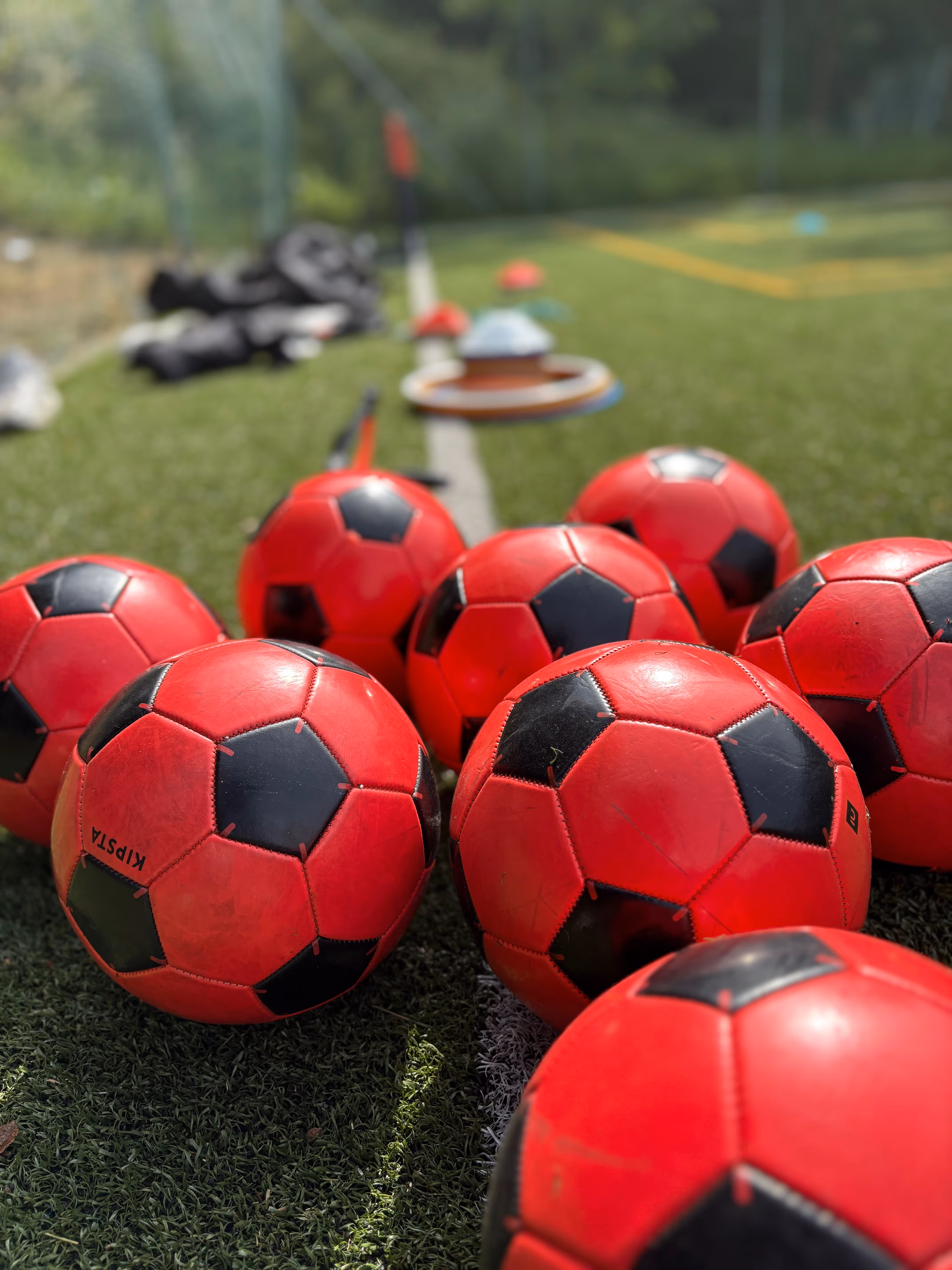 huits ballons rouge de football sur un terrain de football