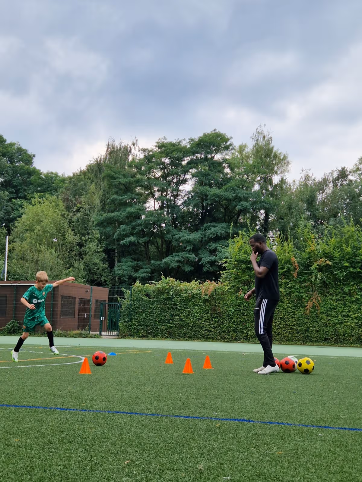 photo de coach Patrick sur terrain de football il entraine Leon un joueur