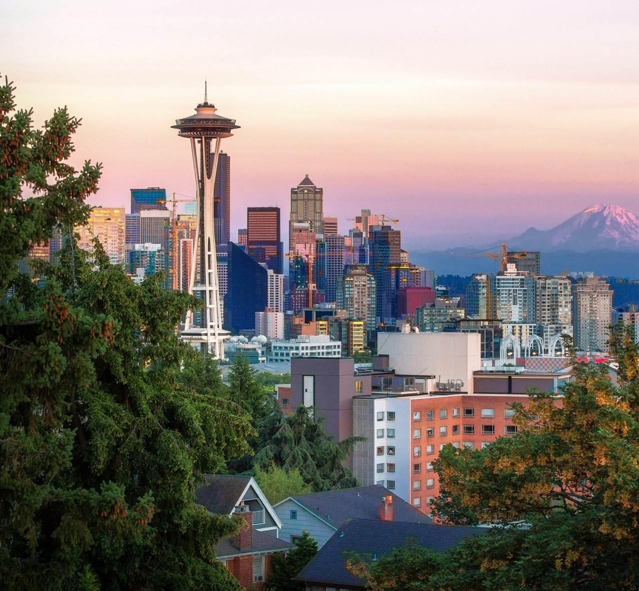 Seattle space needle and Mount Rainier in a pink and orange sunset