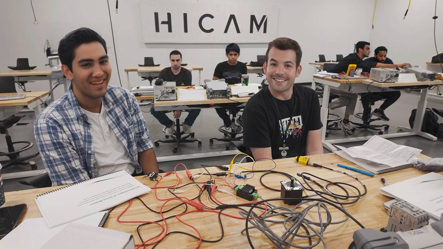 engineering students in a high tech classroom collaborating on their robotics projects