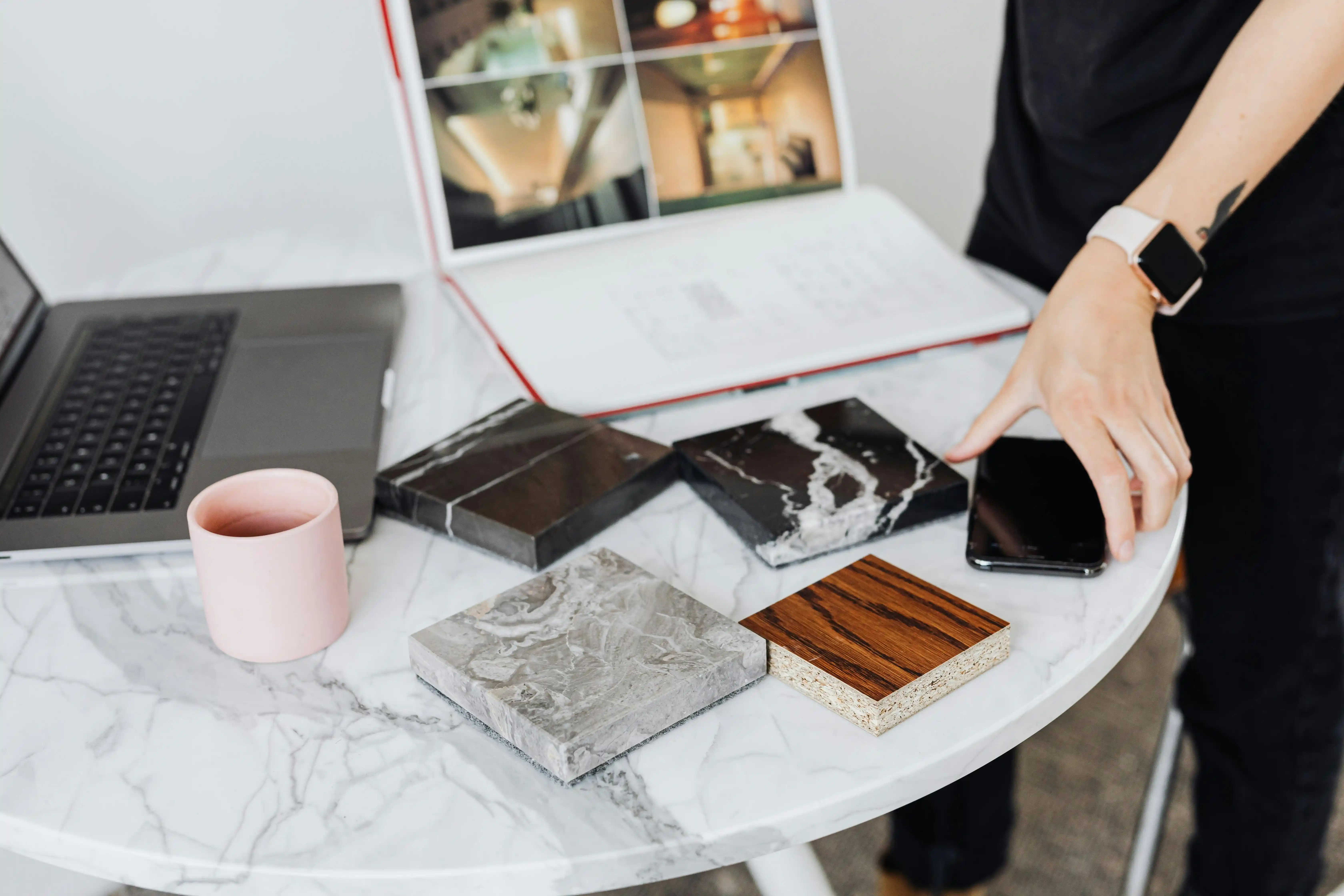 table with laptop showing design and coaster shaped material examples