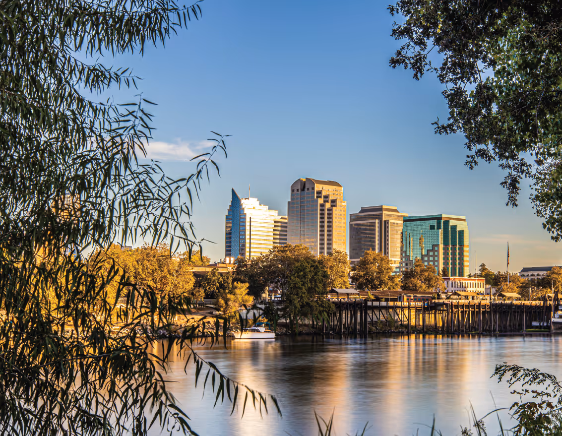 View of downtown Sacramento skyline from across the river framed by trees