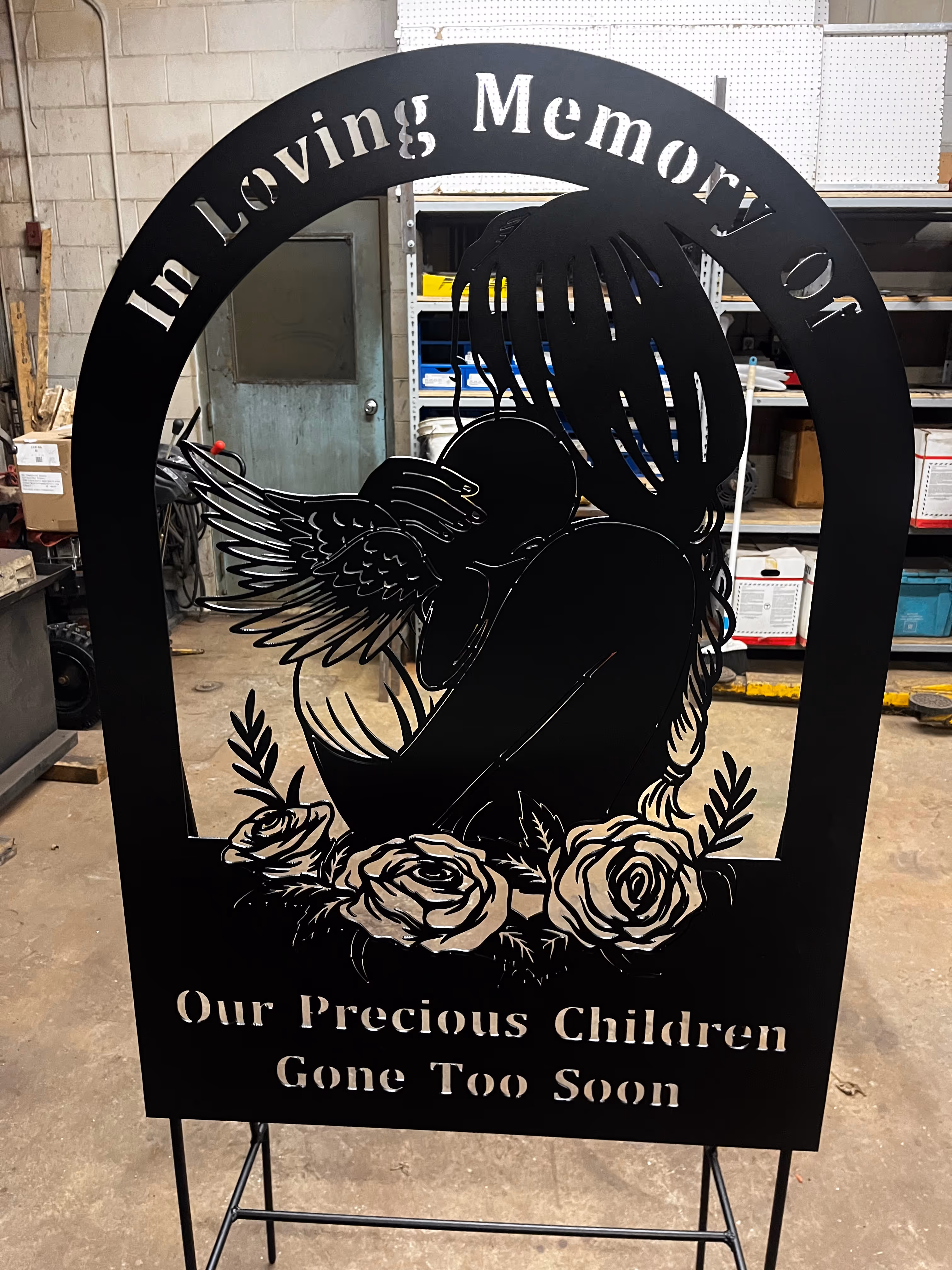 Black metal sign that says "in loving memory of our precious children gone too soon"