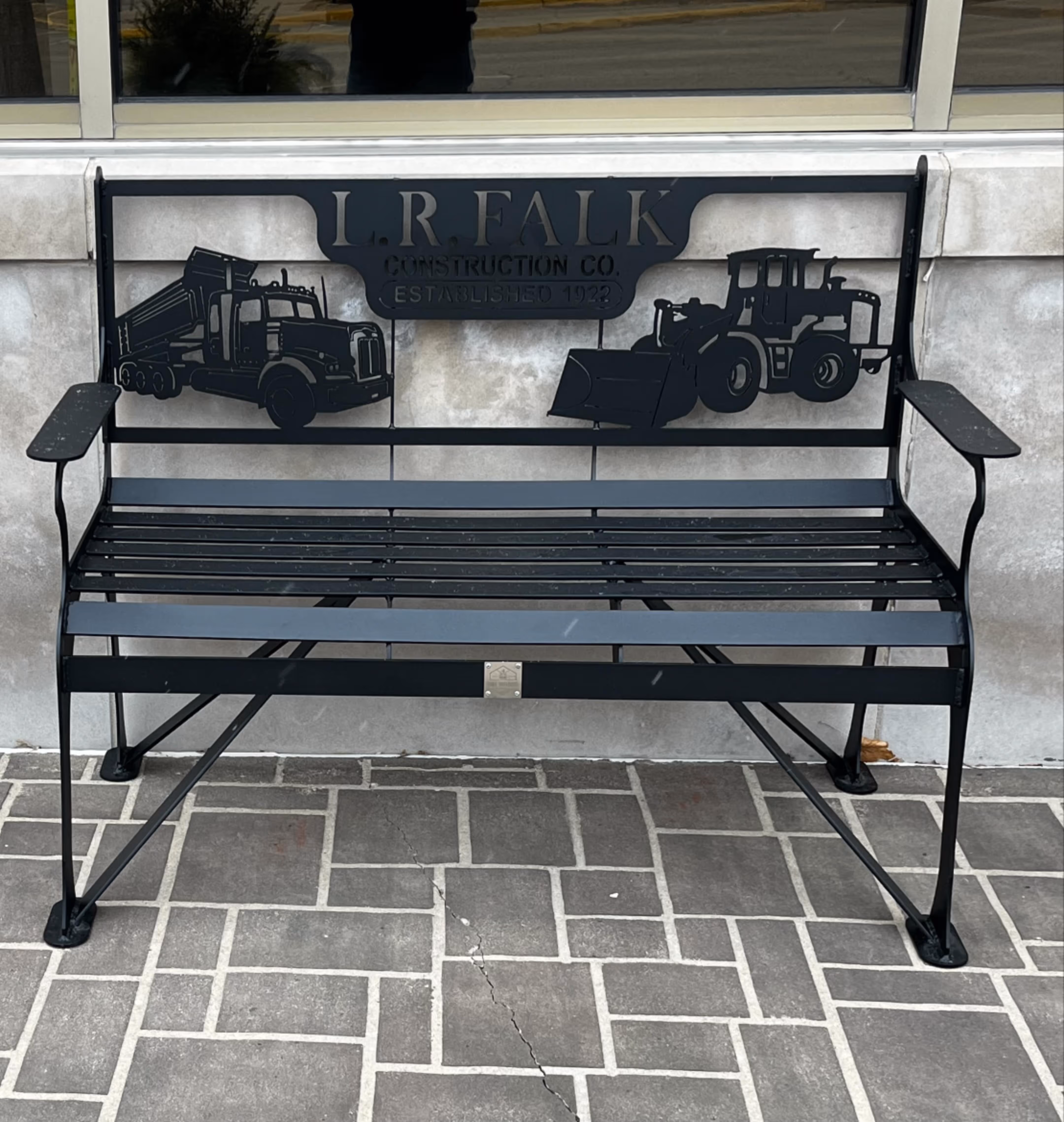 Black Metal bench with machinery and it says "LR Falk"