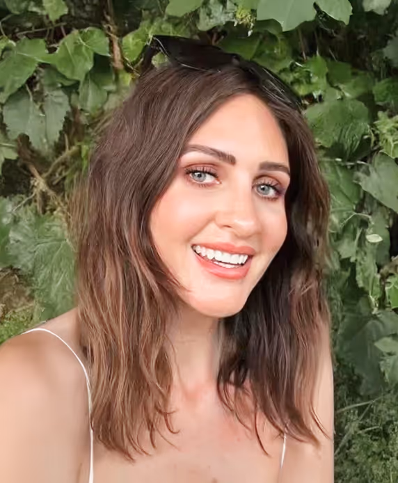 Smiling woman with long hair, promoting personalized beauty treatments at Natural Beauty by Helen in Twickenham, London.