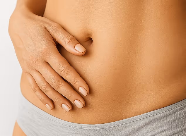 Close-up of a woman's abdomen with a gentle hand resting, highlighting natural beauty and wellness treatments at Helen's clinic.