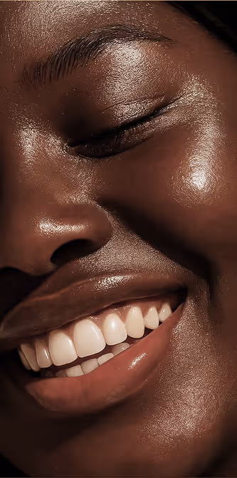 Close-up of a smiling woman showcasing healthy skin, representing beauty and wellness treatments at Natural Beauty by Helen in Twickenham.