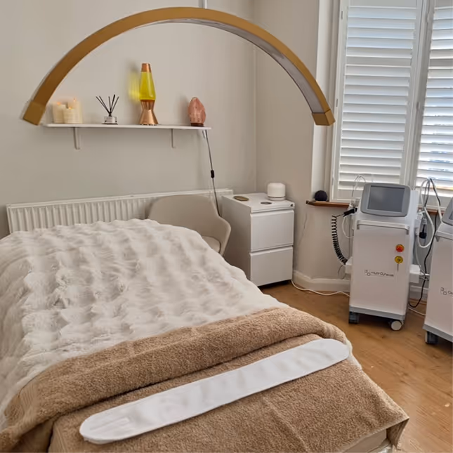 Cozy beauty treatment room at Natural Beauty by Helen in Twickenham, featuring a massage bed and wellness equipment.