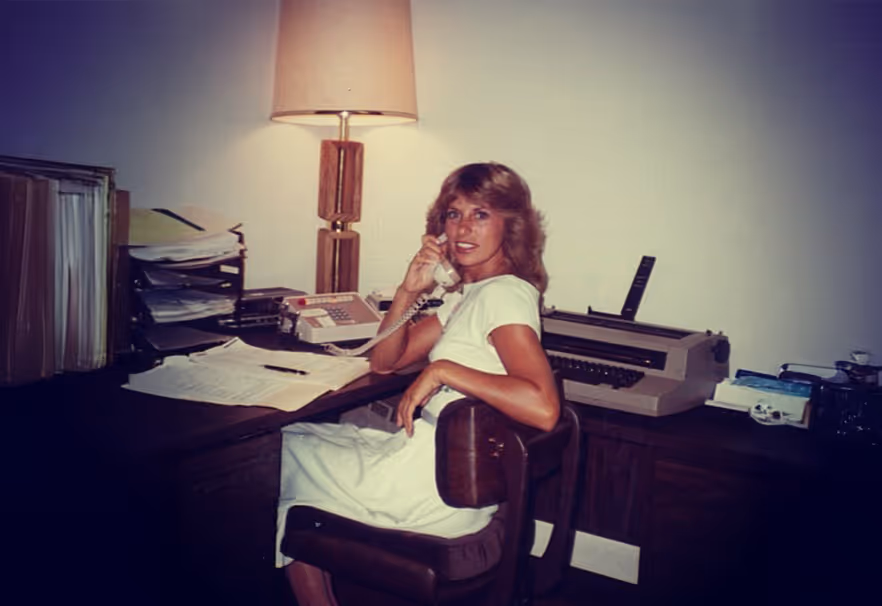 Jan Lhotka at a desk during ActionLife’s early years, pictured with vintage office equipment.