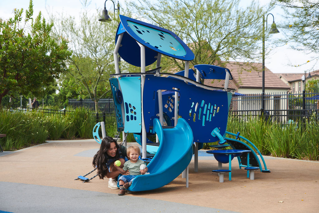 Children playing at a blue playground in an ActionLife community.