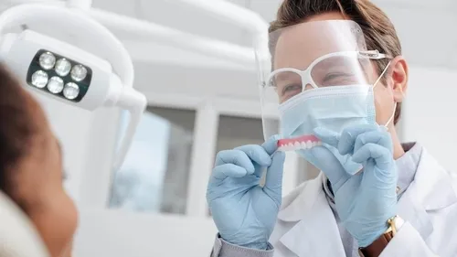 A woman in a white lab coat and goggles.