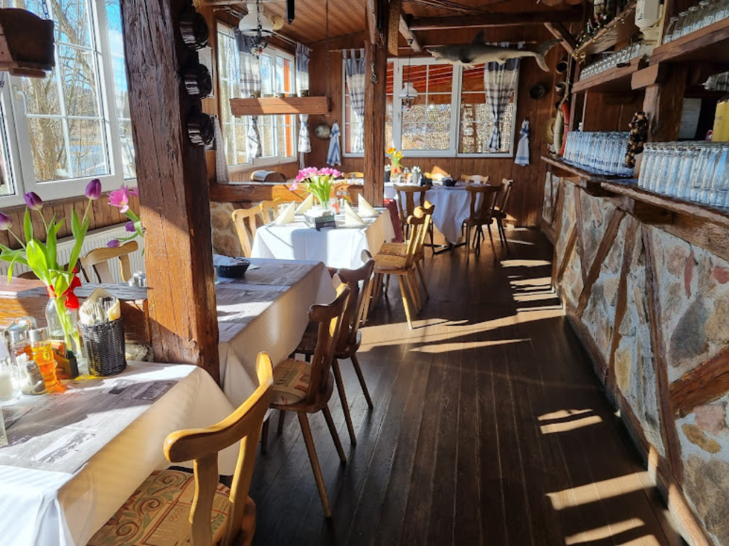 Vnitřní prostor restaurace s dřevěným obložením a prostřenými stoly