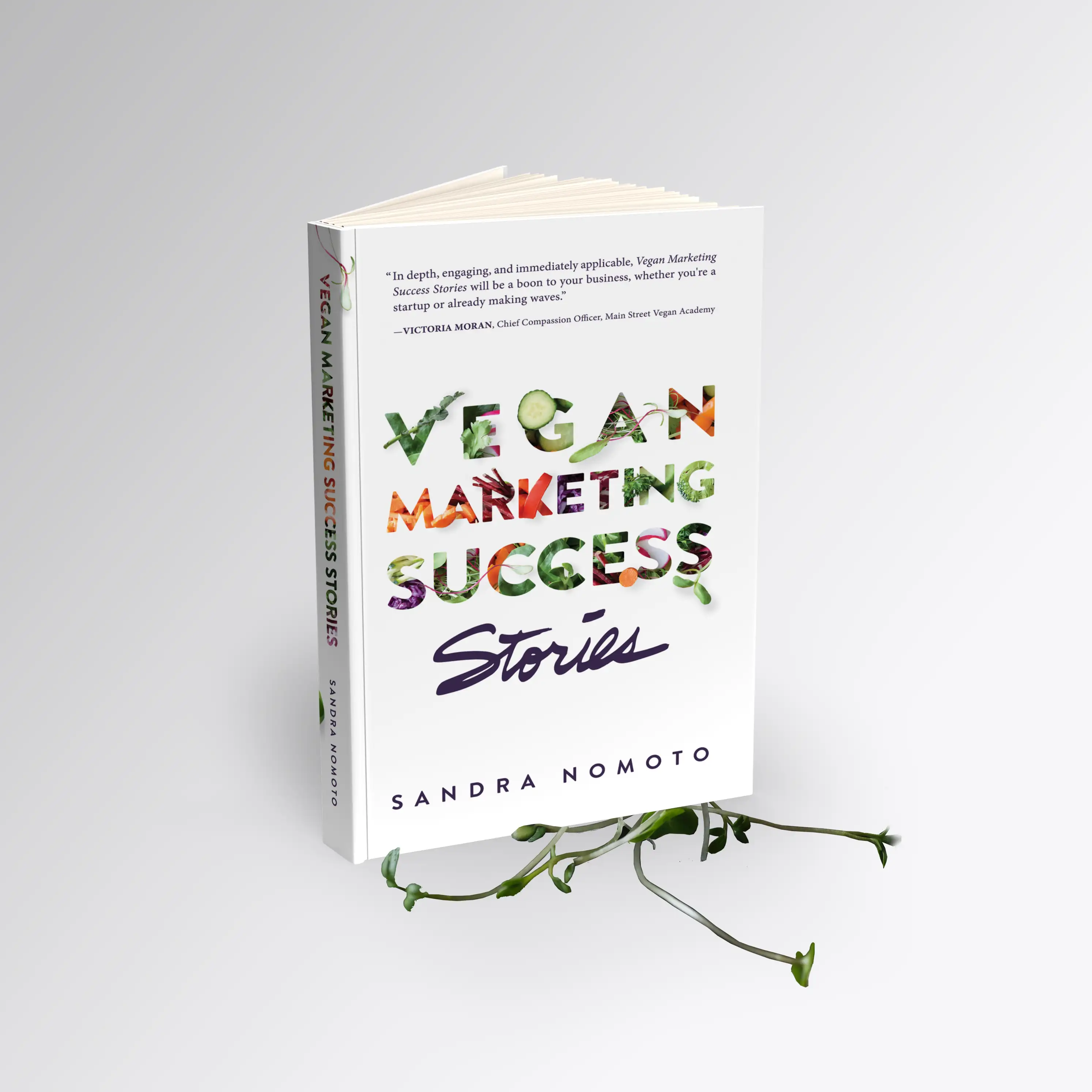 Image of a book cover design by Joy. The book cover says "Vegan Marketing Success Stories" and is made of letters which are taken over by vegetables and green leaves. The word "stories" is handwritten. The author is Sandra Nomoto. The book is positioned standing up, on top of green sprouts that spread around the book.
