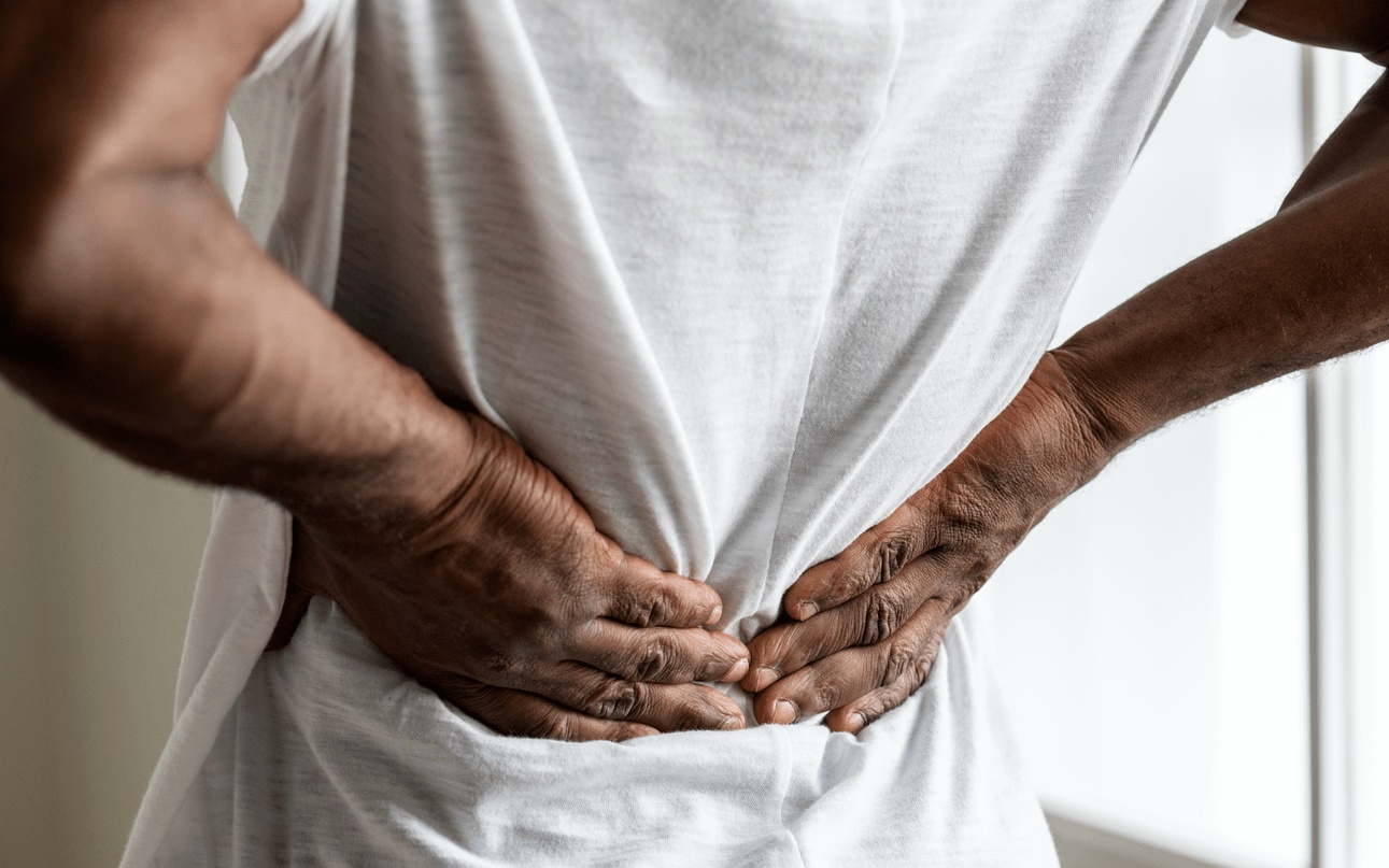 Man holding his lower back in pain while seeking treatment from the best chiropractor in Hoover.