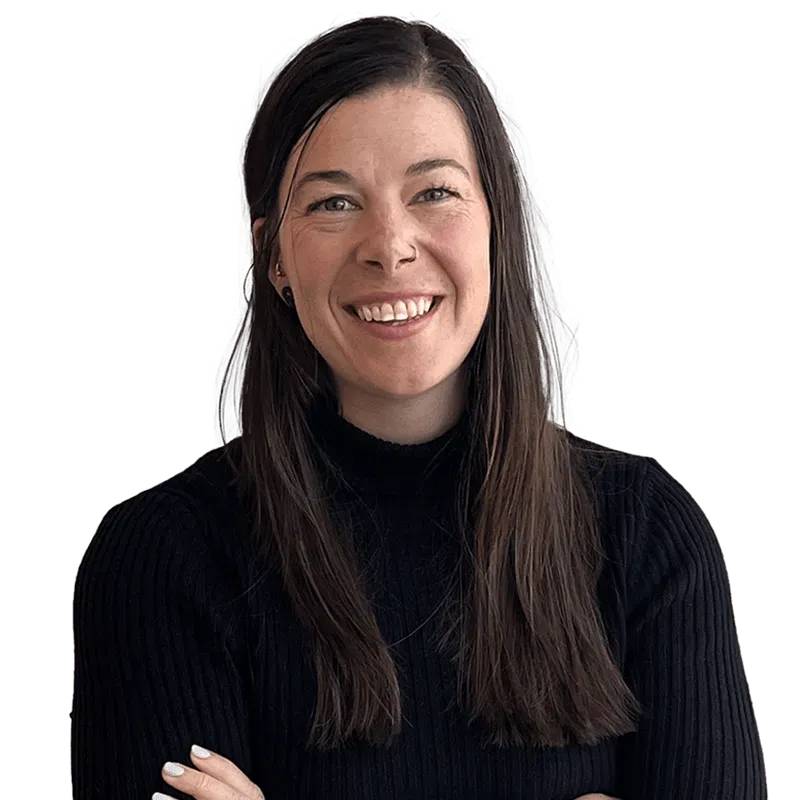 Smiling woman with long brown hair wearing a black ribbed turtleneck sweater with arms crossed.