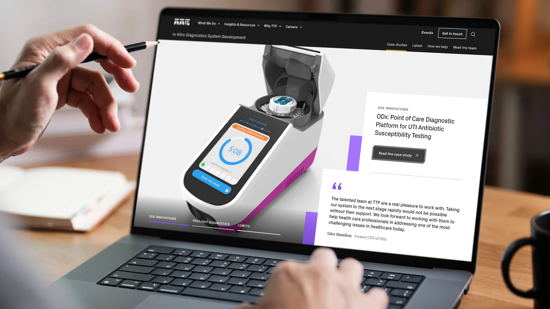 Person using laptop displaying a point-of-care diagnostic device for UTI antibiotic testing case study.