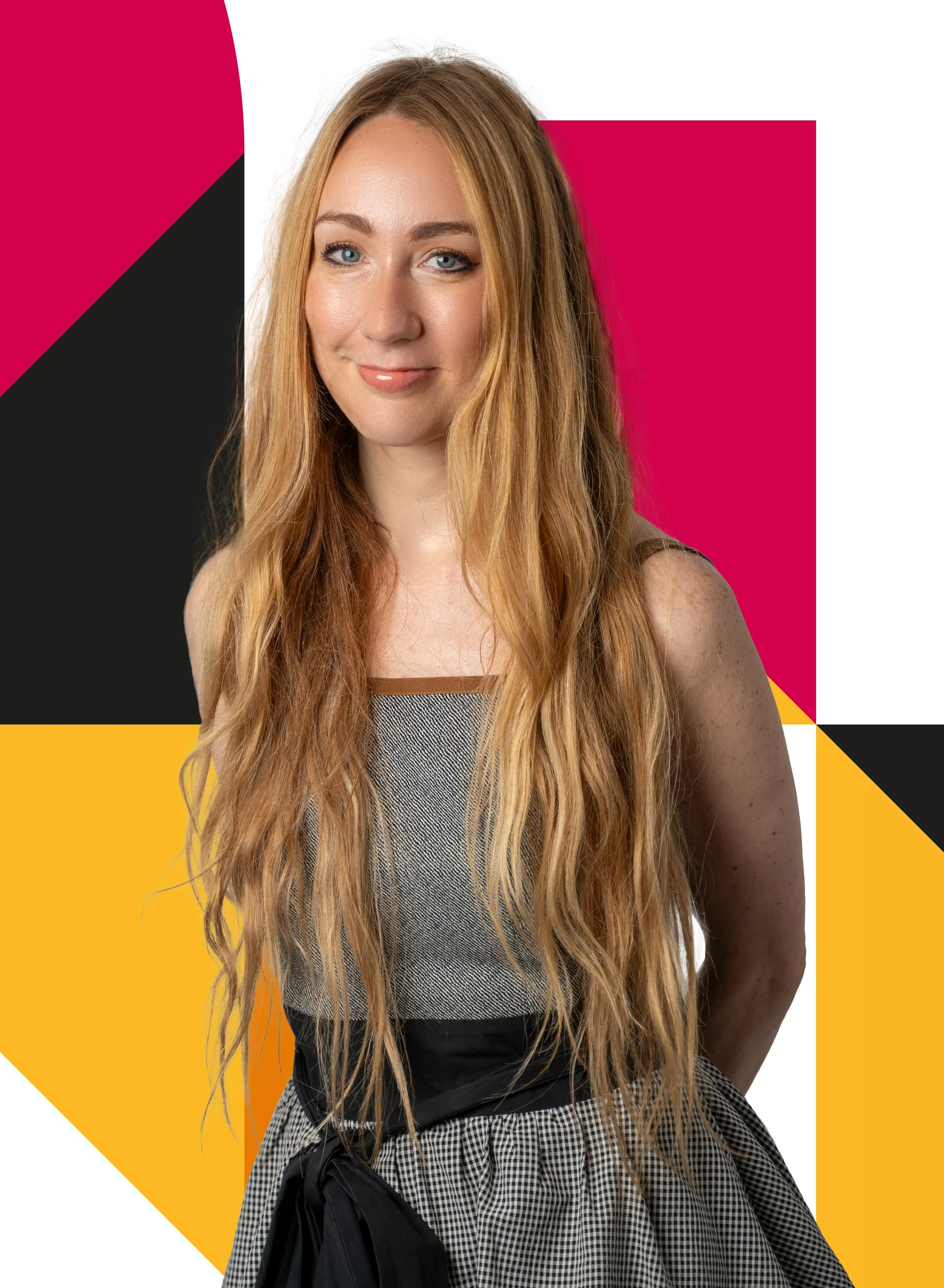 Smiling young woman with long blonde hair wearing a patterned dress with a black sash.