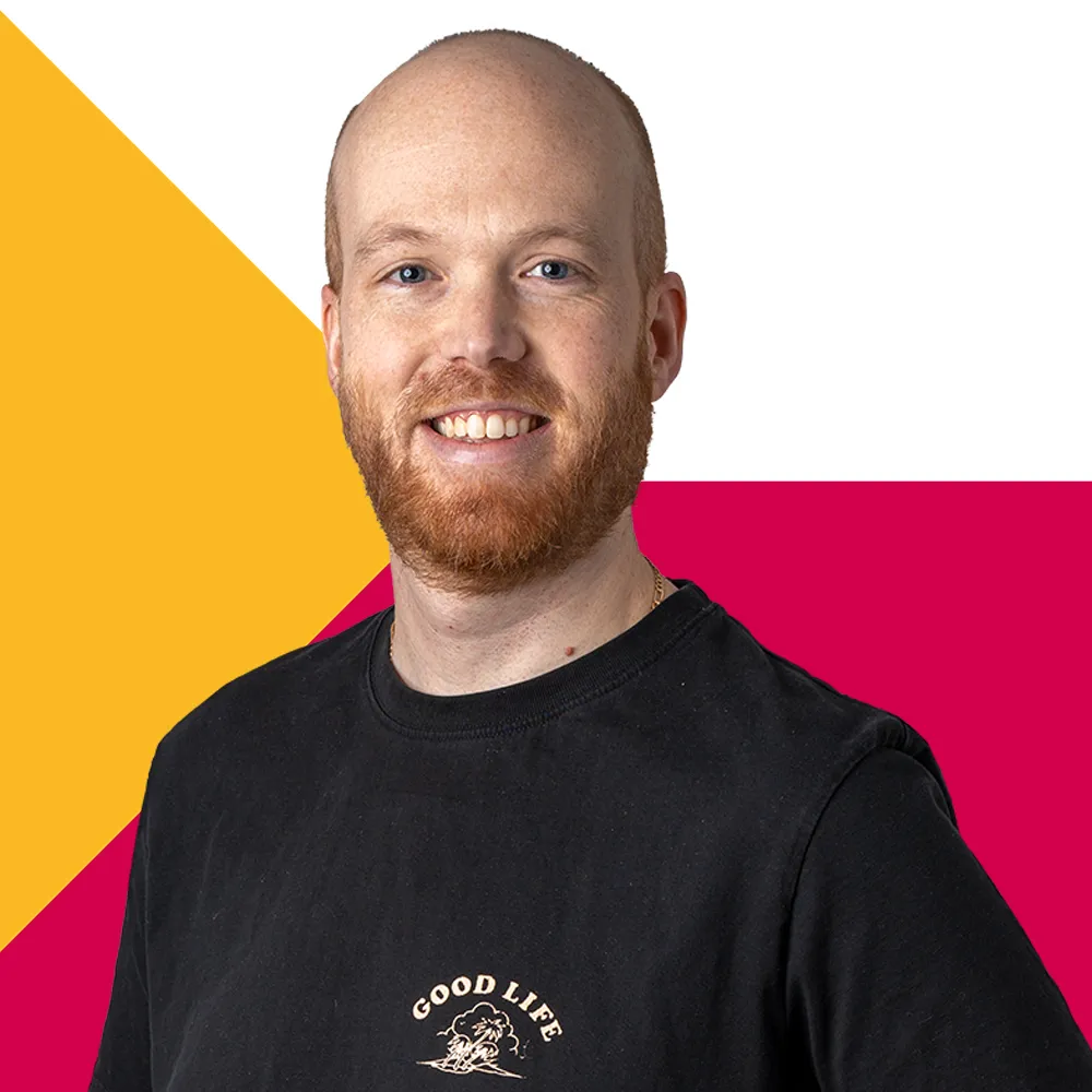 Smiling  man with red beard wearing black shirt with 'Good Life' text.