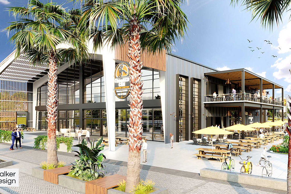 Modern two-story building with outdoor seating, palm trees, and people walking under a blue sky with birds.