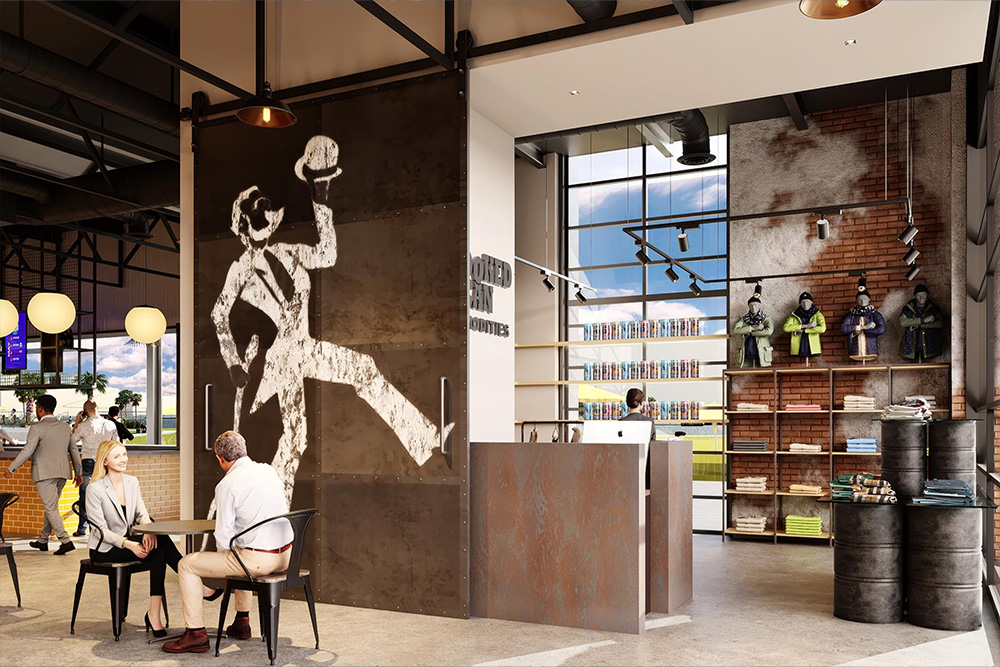 Modern retail store interior with industrial design, featuring people sitting at a table, large wall art of a man tipping hat, shelves with folded clothes and jackets on mannequins.