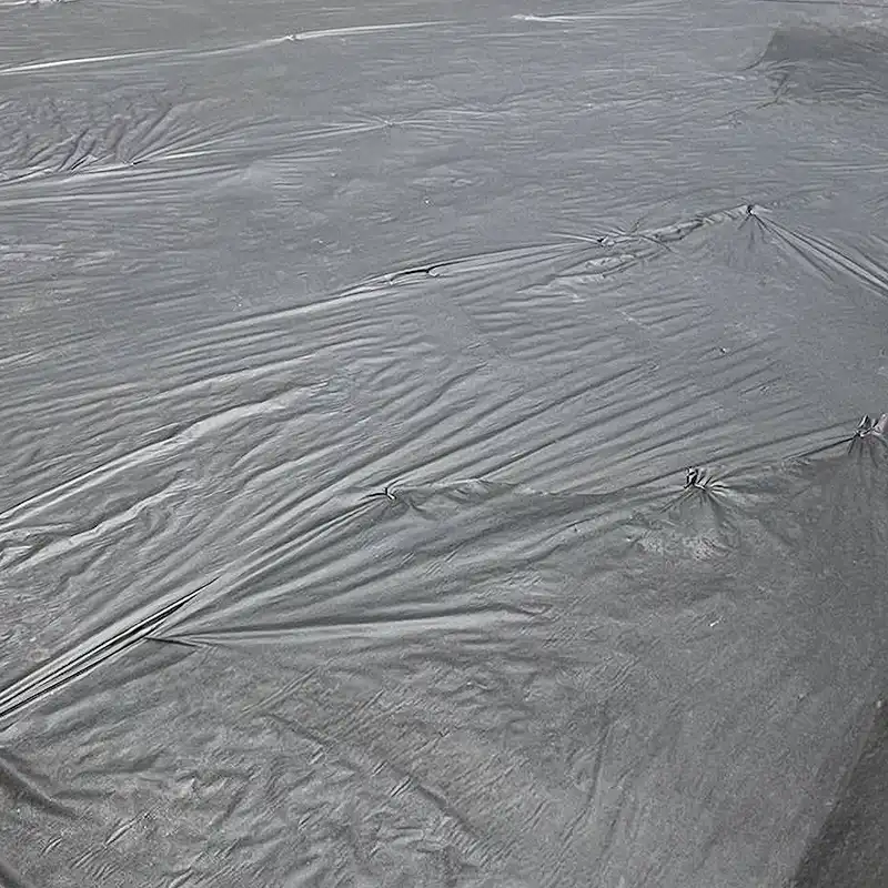 Landscape fabric installed beneath decorative rock during a High Desert landscaping project
